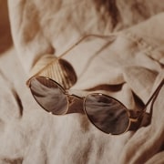 A sepia-toned image of sunglasses on a beach towel